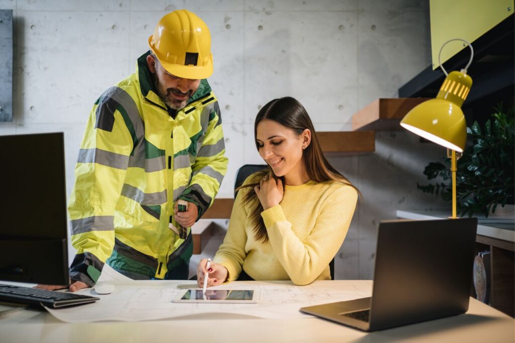 Pracownik BHP i kobieta analizują dokumenty przy biurku