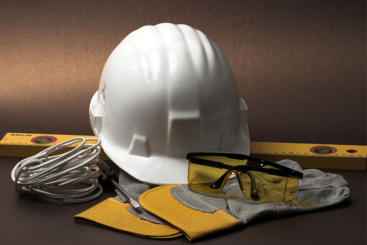 Kask i okulary ochronne ułożone na stole roboczym