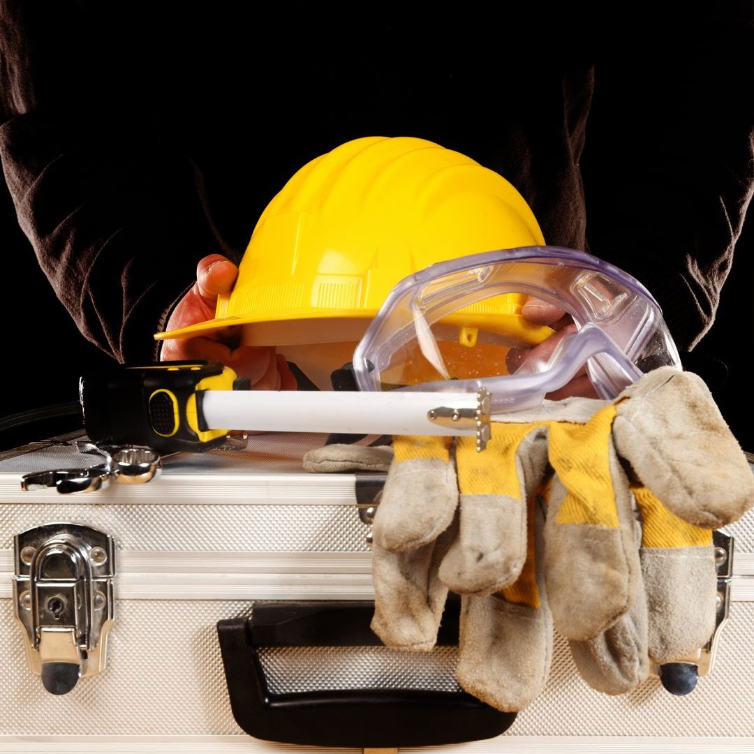 Sprzęt BHP: kask, rękawice i okulary ochronne na skrzynce narzędziowej