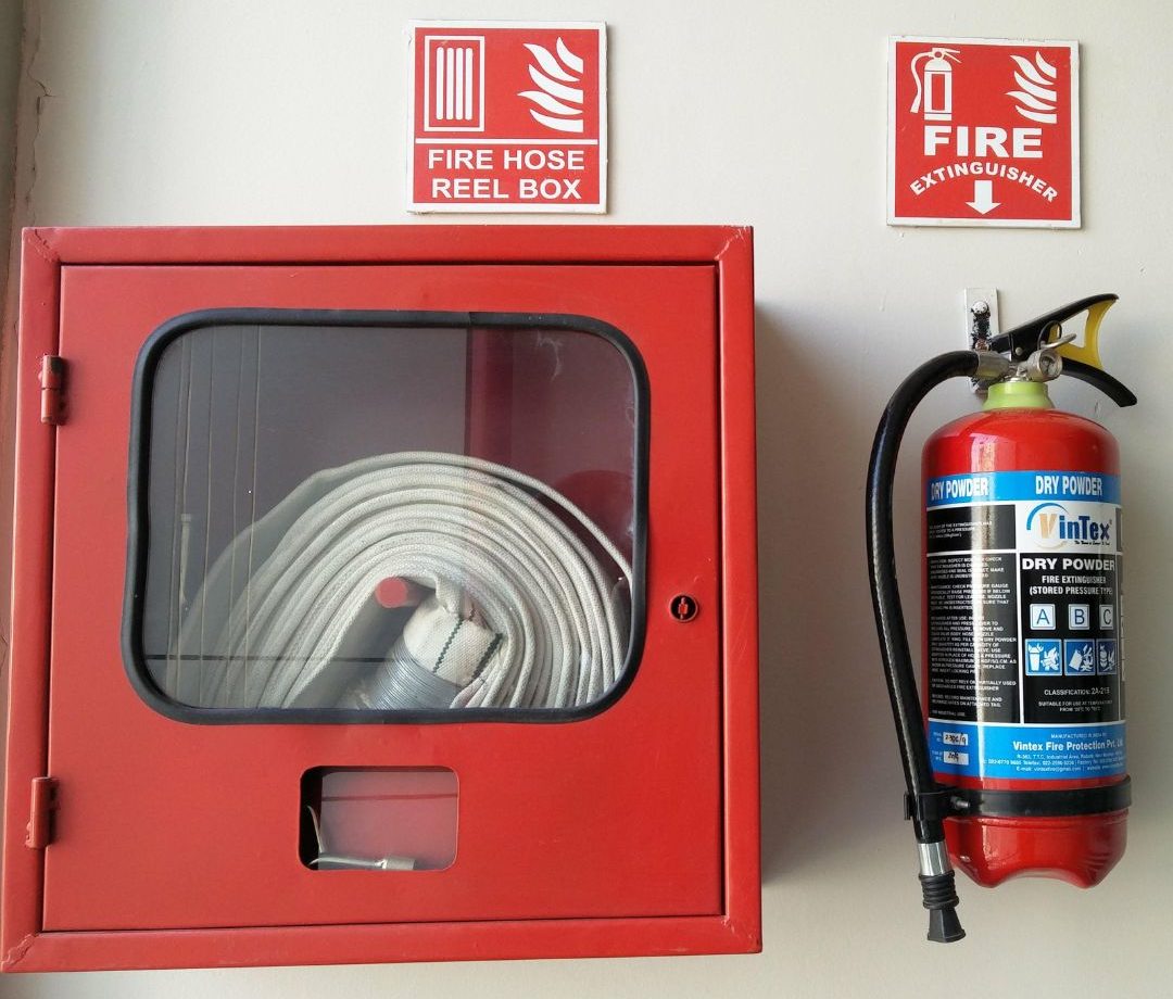 Hydrant i gaśnica zamontowane na ścianie w budynku